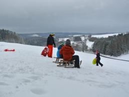 Kinder beim Schlittenfahren im Schnee